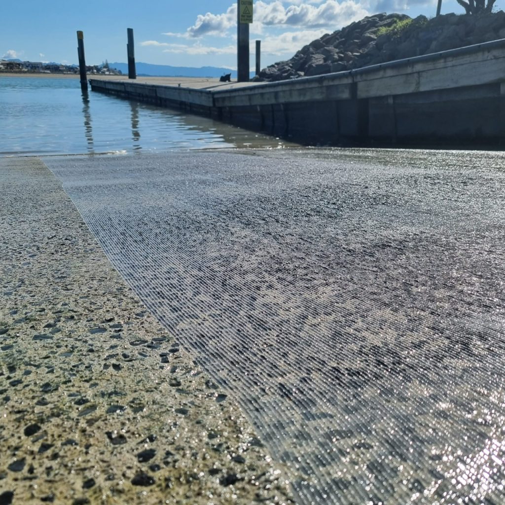 Close up side by side image of a concrete boat ramp with before and after channel cutting planing