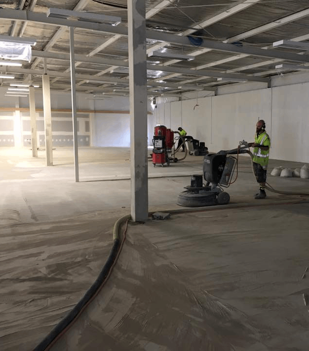 a concrete floor in a warehouse being prep grind for polished concrete