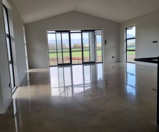 Salt and pepper finish for a beach house polished concrete floor nz grinders tauranga lounge area